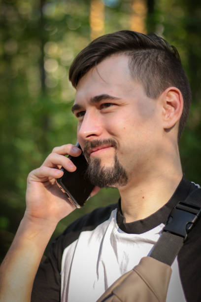 Guy's talking on the phone in the park. High quality photo