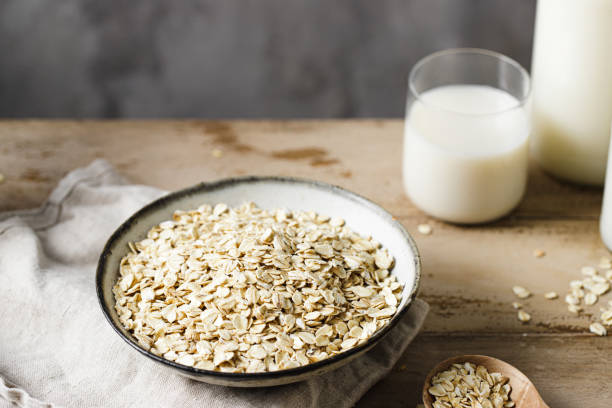 istock Organic oats in a ceramic bowl with oat milk glass on table 2154004566