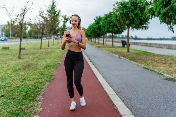 istock Woman jogging and using smartphone in park 2154009442