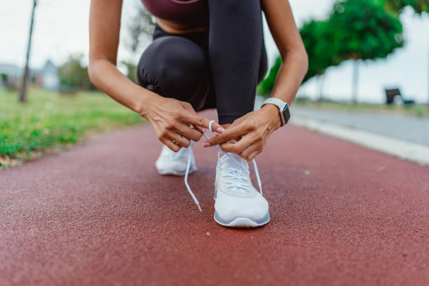 istock Runner tying shoelaces on track 2154009469