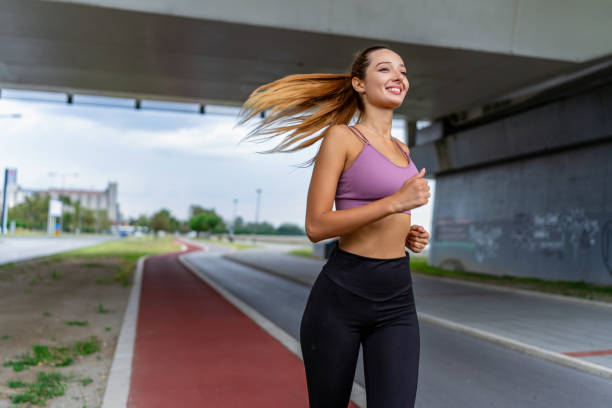 istock Young woman jogging under bridge 2154009742