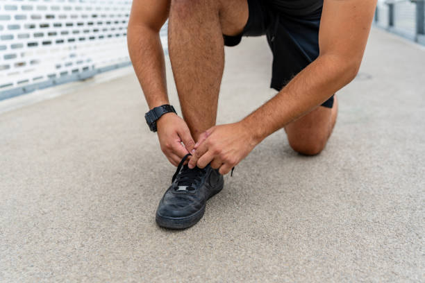 istock Person tying shoe lace on running track 2154009870