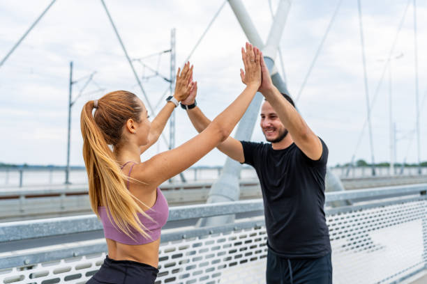 istock Two people high-fiving on a bridge 2154010052