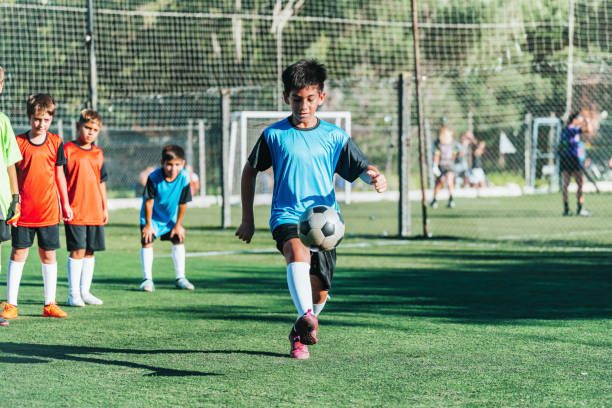 istock boy showing skills with soccer ball on field 2154010528