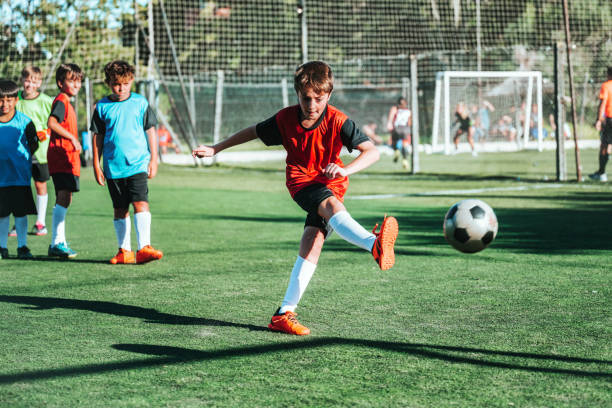 istock soccer boy kicking the ball on field 2154010591