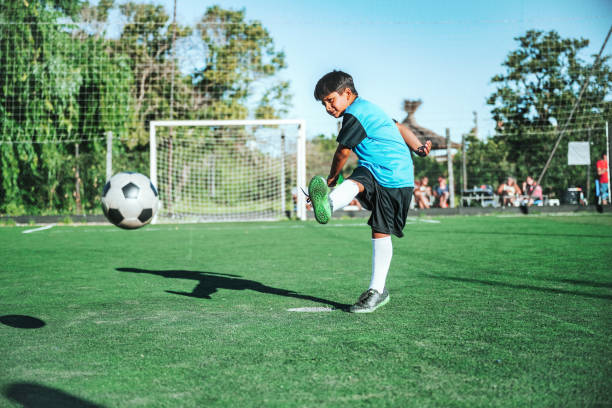 istock soccer boy kicking the ball on field 2154010683