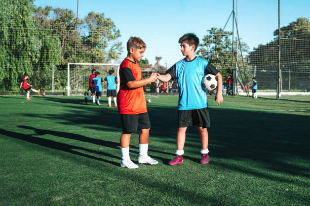 istock two boys from opponent teams shaking hands after match 2154010761