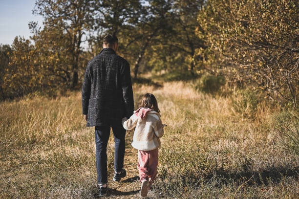 Family walking in autumn forest.