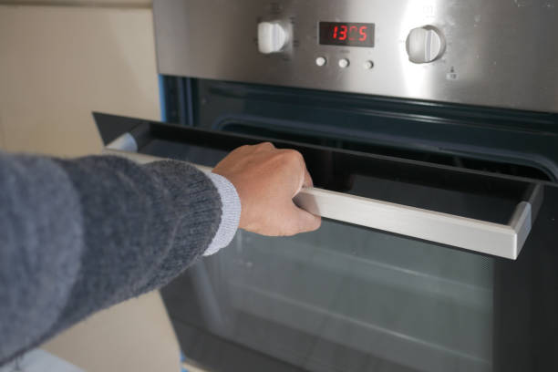 istock hand open the electric oven door at home 2154014467