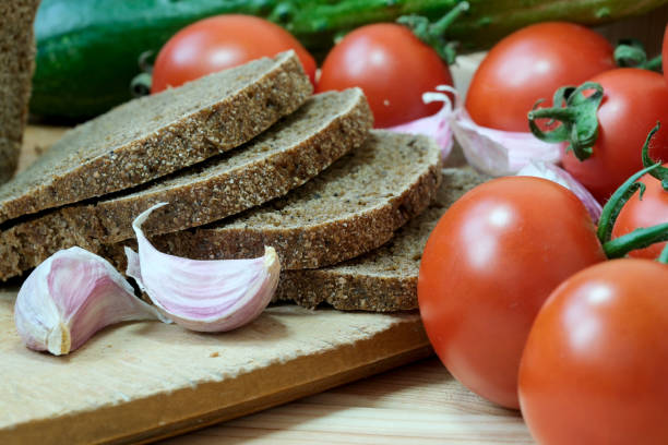 Fresh bread slices and ripe tomato slices arranged on a cutting board.