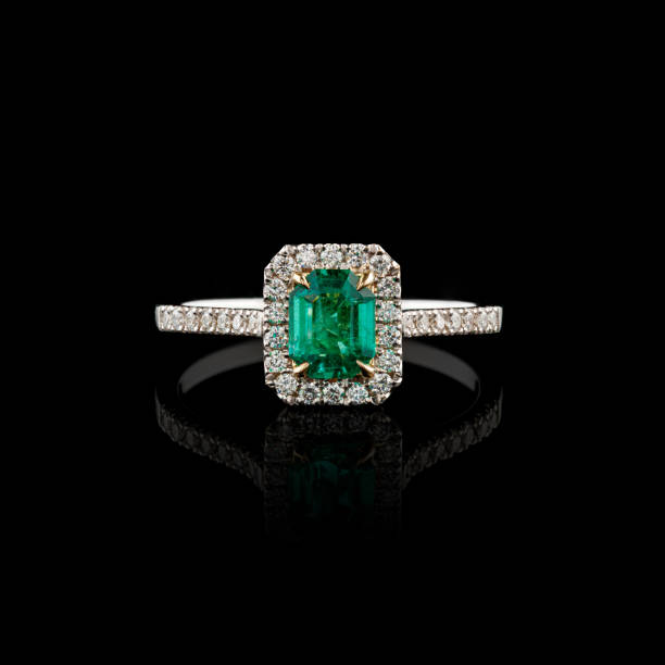 istock Beautiful white gold ring with diamonds and emerald on a black background 2154016763