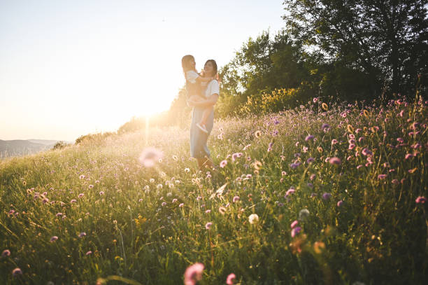 Young family in a sunset meadow.