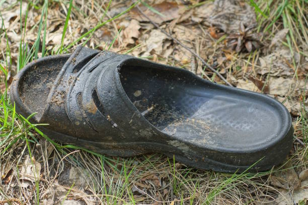istock one old dirty rubber gray slipper on gray sand 2154025444