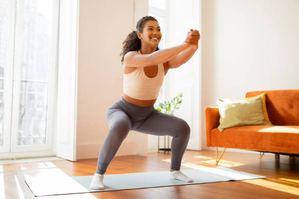 istock lady athlete performs squats and stretches her arms forward indoor 2154027781