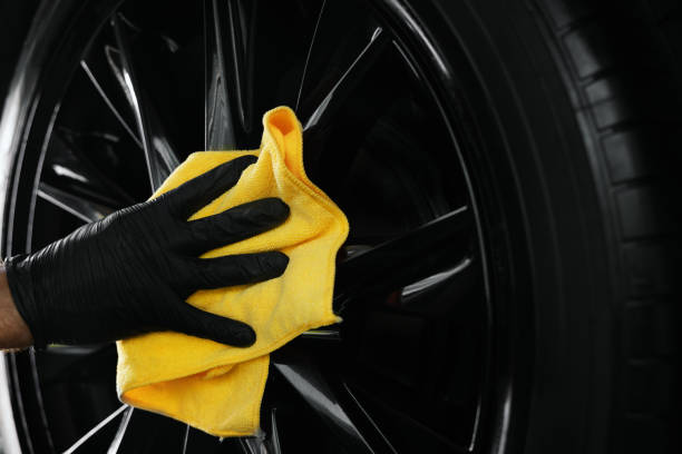 car detailing. hand is cleaning a black alloy wheel with microfiber cloth car detailing. hand is cleaning a black alloy wheel with microfiber cloth fabric edge stock pictures, royalty-free photos & images