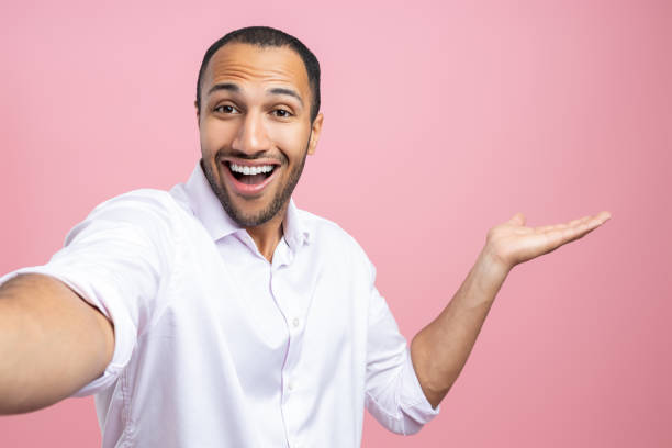 istock Cheerful man in white shirt making selfie presenting copy space 2154029039