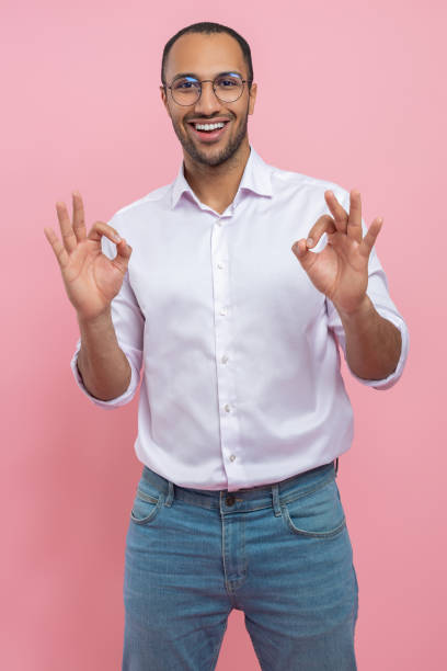 istock Satisfied man in white shirt showing okay gesture 2154029051
