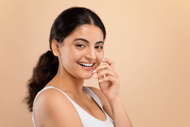 istock Graceful young indian woman in white top gently touching her face 2154031400