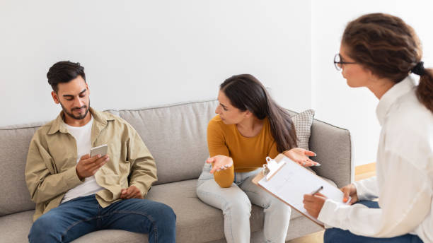 istock Couple consulting with counselor, man using phone 2154036195