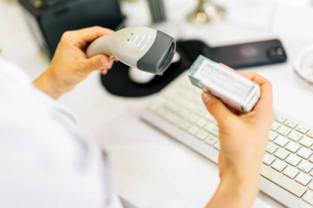 Midsection of female shop assistant using barcode reader on jar in supermarket