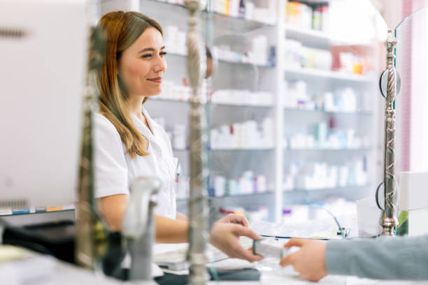 Woman pharmacist consulting customer at counter for prescription drugs or medicine at the pharmacy. Female doctor giving patient medical antibiotics at the pharmacy stock photo