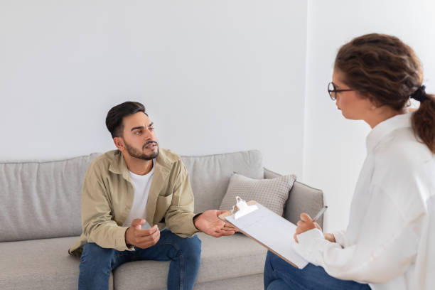 istock Man in therapy session with counselor at office 2154036253