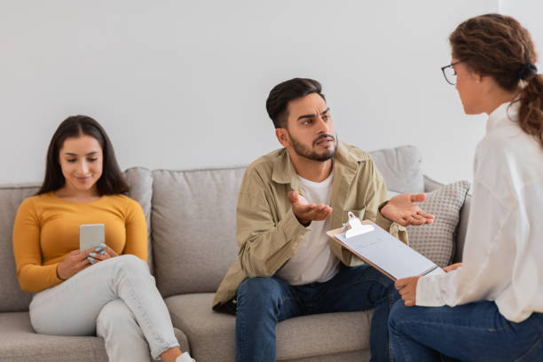 istock Man discussing with woman therapist holding clipboard 2154036298