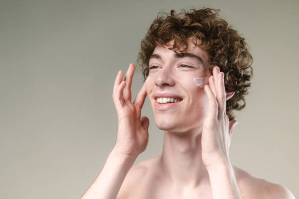 istock Young man applying a face cream and enjoying 2154039731
