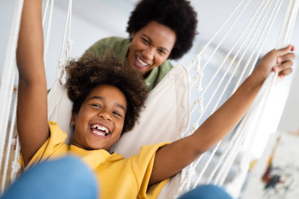 istock Playful young African American girl having fun with mom at home 2154040407