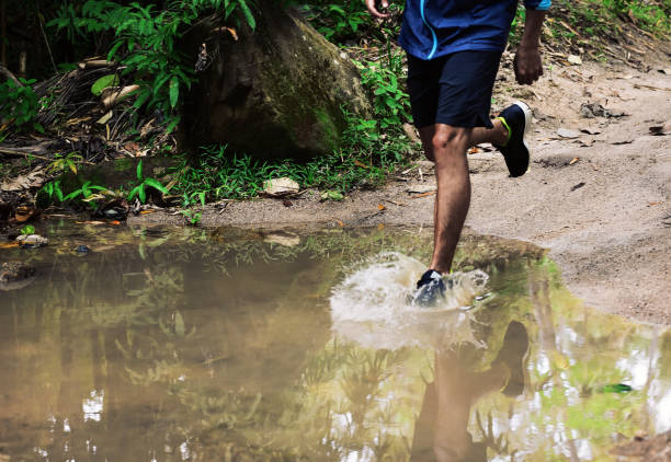 Strong man trail runner running in tropical Thailand rainforest