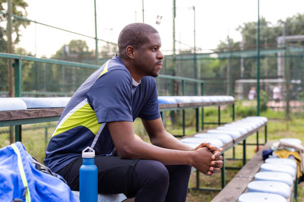 istock Athlete resting on bench after workout at sports field 2154042901