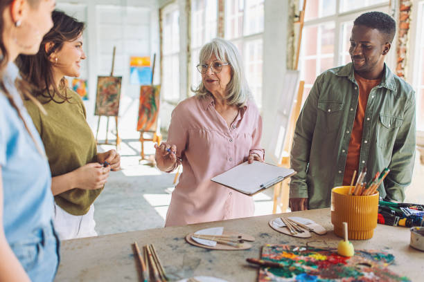 istock Creative learning - art teacher guiding students in painting workshop 2154048265