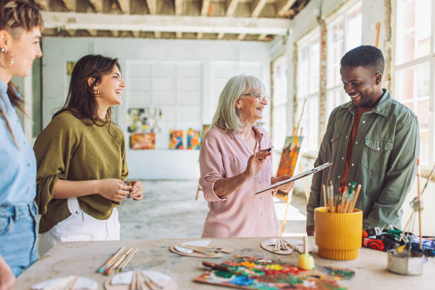 istock Art teacher leading a painting class with students 2154048296