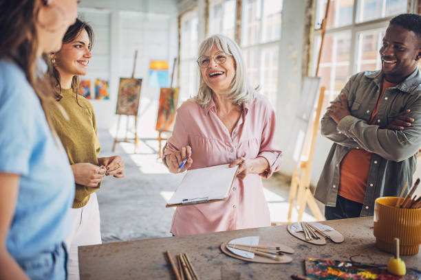 istock Art class creativity - students painting on canvas with teacher 2154048819