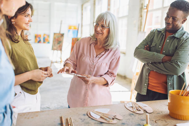 istock Art instructor guiding students in painting workshop 2154048840