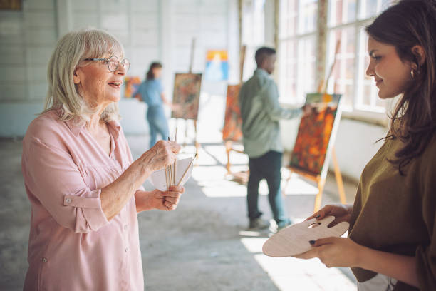 istock Art class in progress: teacher guiding student in painting techniques 2154050624