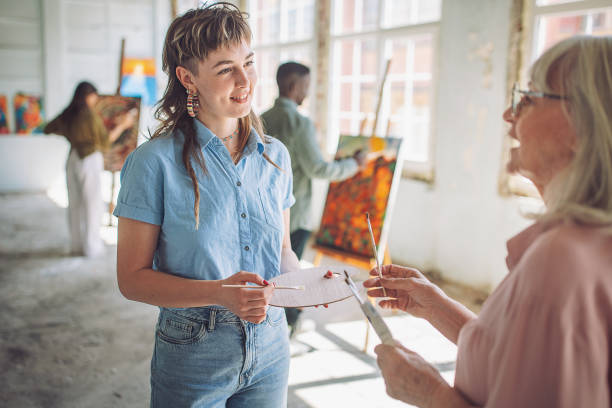 istock Art class engagement: teacher guiding students in canvas painting 2154051864