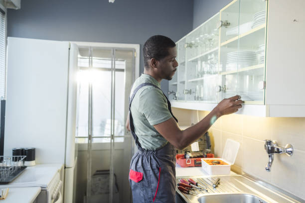 istock African American carpenter is repairing the kitchen unit 2154051875