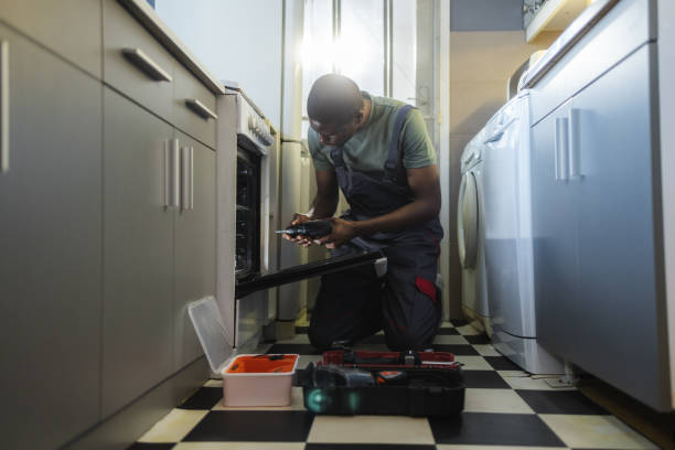 istock The handyman detects the problem and repairs the oven 2154052019