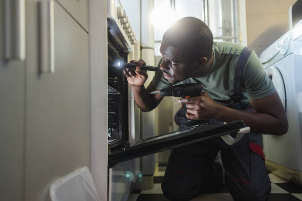 istock The handyman detects the problem and repairs the oven 2154052021