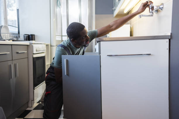 istock Male plumber repairs a broken water pipe under the sink 2154052169