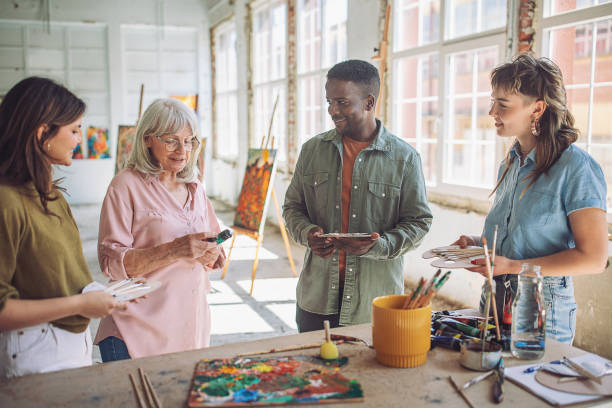 istock Art class creativity: teacher guiding students in canvas painting 2154052220