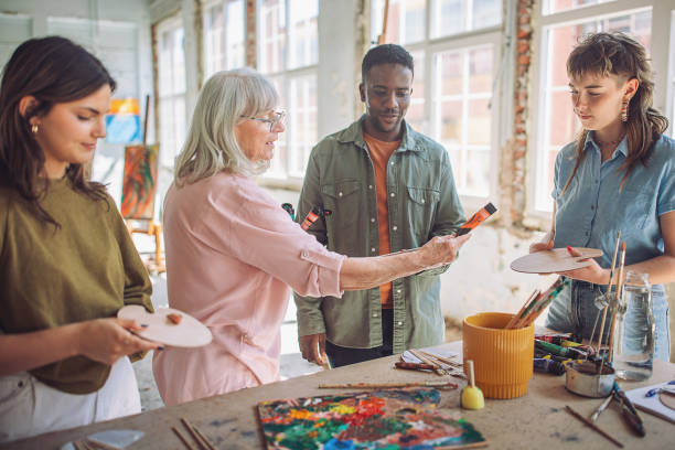 istock Art class in session: teacher guiding students in painting 2154052304