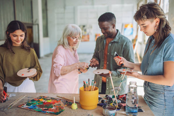 istock Art class engagement: teacher and students painting on canvas 2154052412