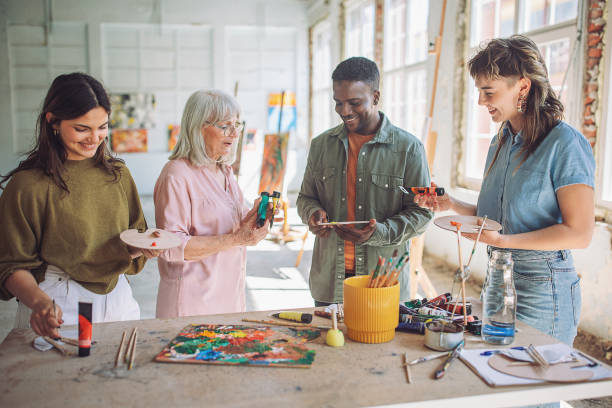 istock Art class creativity: teacher and students engaged in painting 2154052431