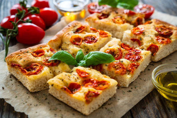 istock Focaccia - roasted mozzarella sandwiches with ham, tomatoes and arugula on black stone plate 2154052441