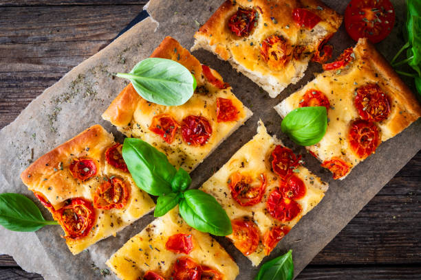 Focaccia - roasted mozzarella sandwiches with ham, tomatoes and arugula on black stone plate