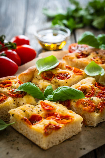 istock Focaccia - roasted mozzarella sandwiches with ham, tomatoes and arugula on black stone plate 2154052457