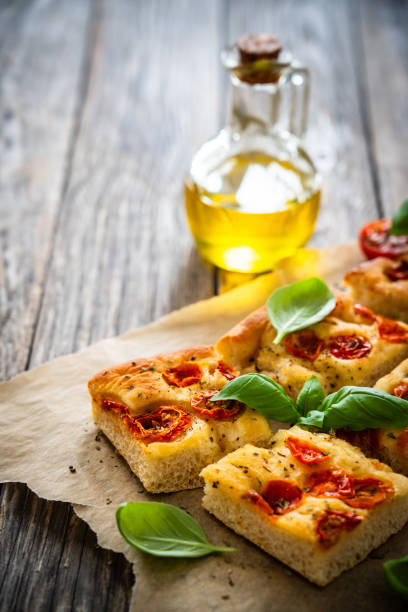 istock Focaccia - roasted mozzarella sandwiches with ham, tomatoes and arugula on black stone plate 2154052467