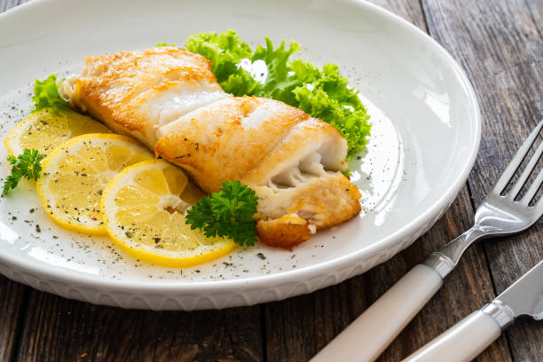 istock Fried halibut steak and fresh vegetables on wooden table 2154052476
